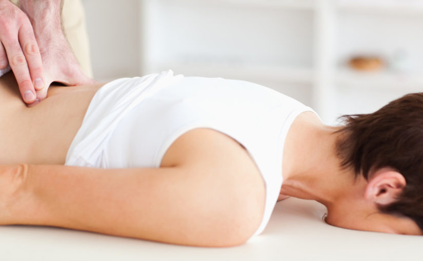 A chiropractor is massaging a woman